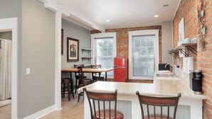 Una cocina con una isla central, un refrigerador rojo y una cafetera.
