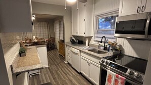 A modern kitchen with white cabinets, a stainless steel oven, a microwave, and a ceiling fan. - Stay Now on the GOTL Strip! Across from Eddie's Grill, Steps from Multiple Bars (Geneva)