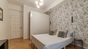 A bedroom with a bed, a wardrobe, a radiator, and a wall with a floral pattern. - Toscana 2bis - FromHometoRome (Roma)