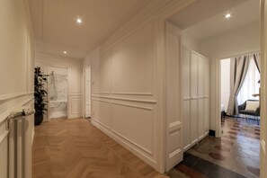 A hallway with a herringbone floor, white wainscoting, and a radiator on the left. - Toscana 5 - FromHometoRome (Roma)