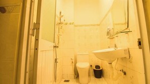 A small bathroom with a toilet, sink, and shower. - Moonie House Saigon (Ho Chi Minh City)