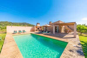 A swimming pool with lounge chairs, a covered patio, and a view of a hillside. - PEDRA VIVA (CALA BONA) - Lovely villa with private pool and free Wifi (Son Servera)
