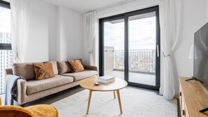 En moderne stue med sofa, sofabord og tv.