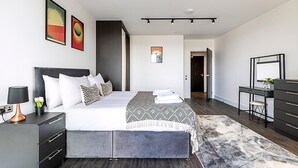 Una camera da letto moderna con un letto grande, comodini, una scrivania e una sedia.
