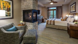 A hotel room with a fireplace, a bed, a sofa, and a television.