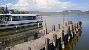 Un bateau était amarré à un quai en bois, avec un lac paisible et des montagnes en arrière-plan.