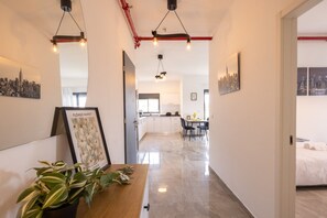 A modern interior with a dining area, kitchen, and a bed in the adjacent room.