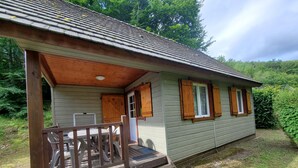 Eine Holzhütte mit Veranda, einem kleinen Tisch und Stühlen.
