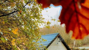 Ein kleines Haus mit einem geneigten Dach, einem Fenster mit Fensterläden und einer Veranda.