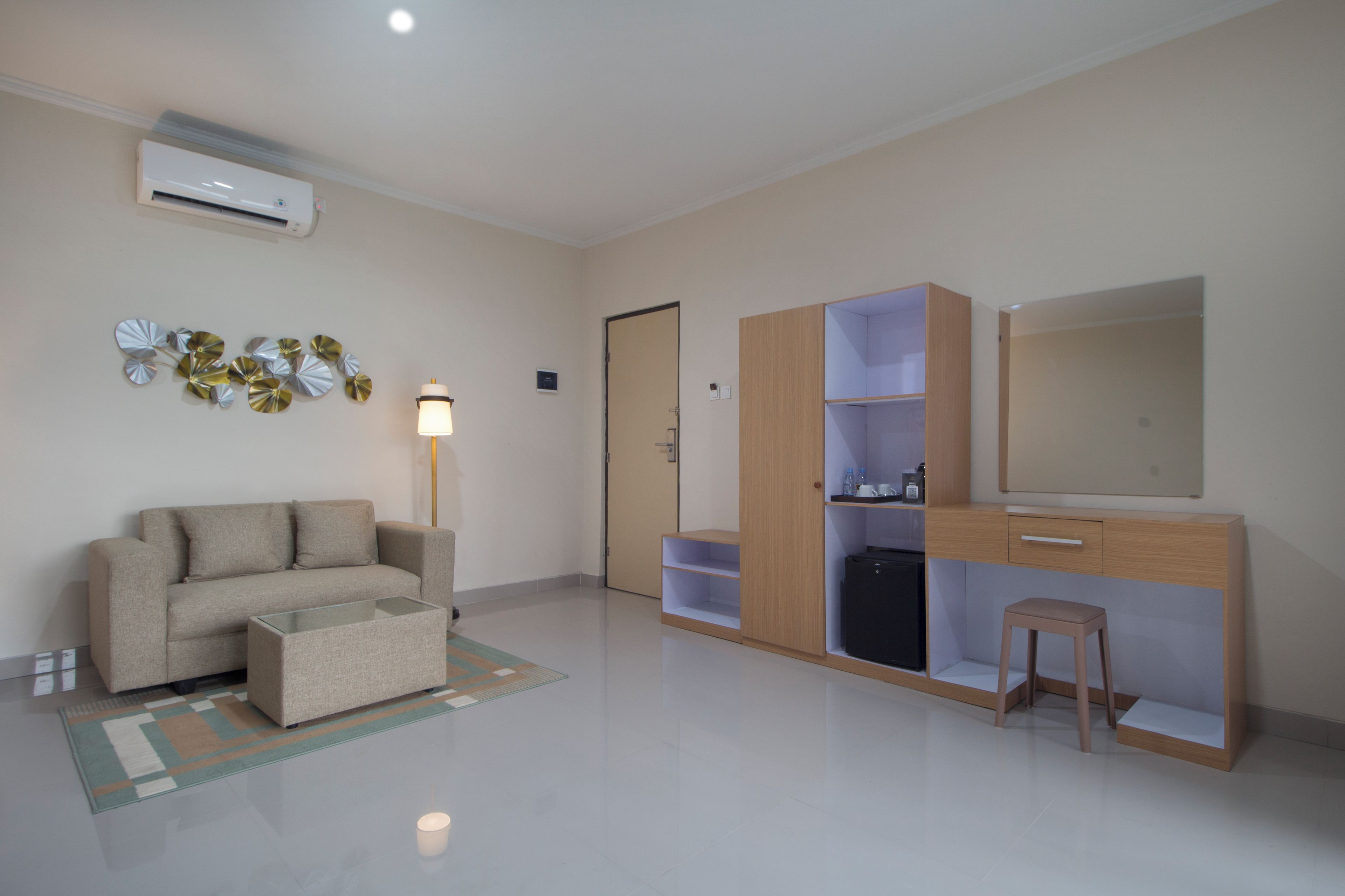 A modern living room with a sofa, a coffee table, a lamp, a wardrobe, and a mirror.