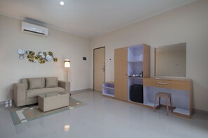 A modern living room with a sofa, a coffee table, a lamp, a wardrobe, and a mirror. - Parigata Resorts Jimbaran (Jimbaran)