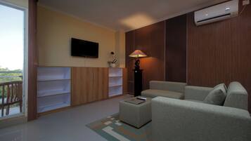 Uma sala de estar moderna com um sofá, uma mesa de centro, uma TV e um abajur.