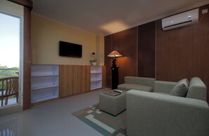 Ein modernes Wohnzimmer mit einer Couch, einem Couchtisch, einem Fernseher und einer Lampe.