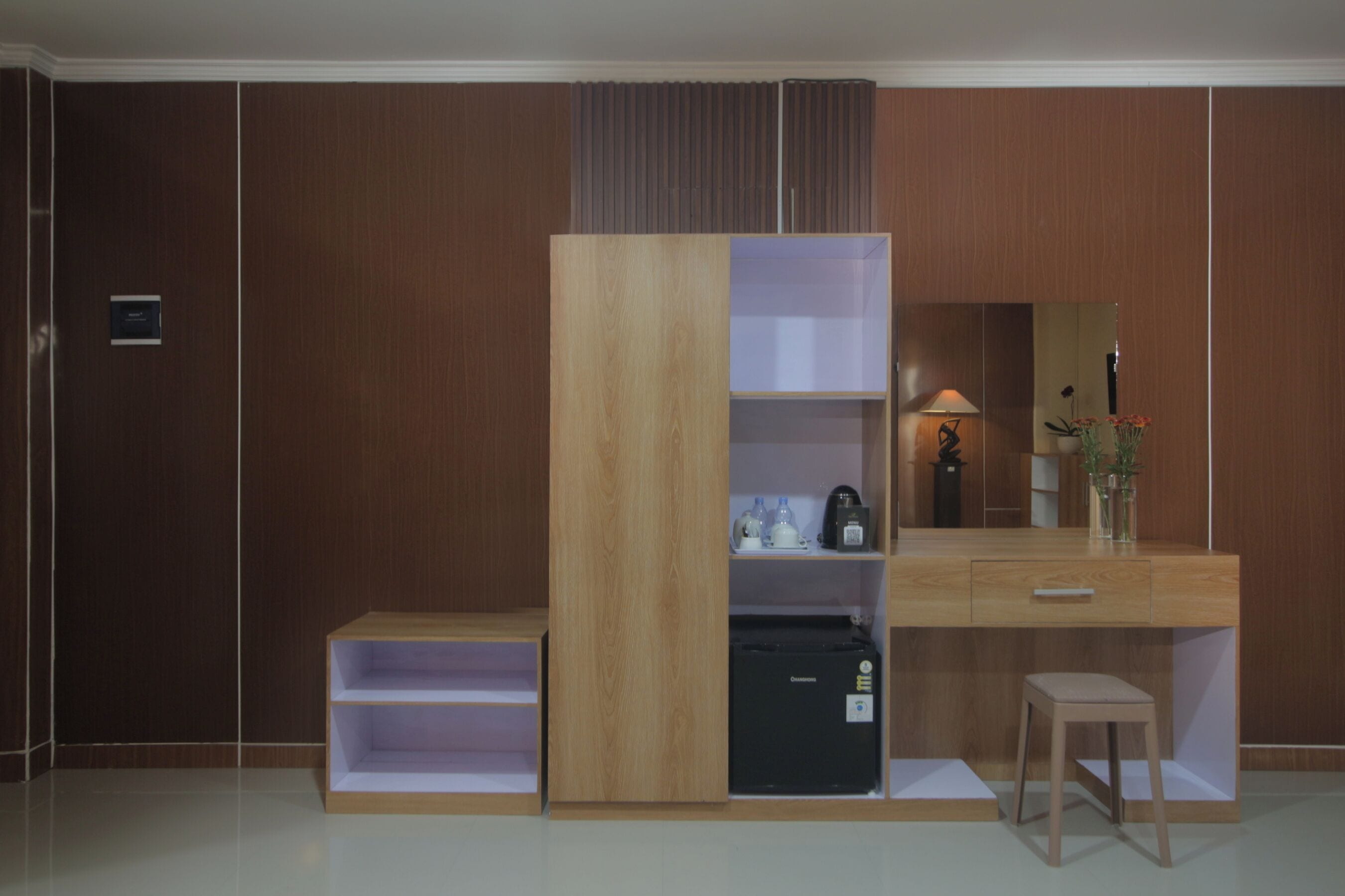 Un dormitorio moderno con un armario de madera, un escritorio con espejo y un pequeño taburete.