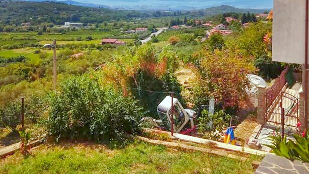 A rural landscape with a house, a garden, and a distant view of fields and houses. - 1 bedroom gorgeous apartment in Dekani (Dekani)