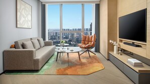 A modern living room with a sofa, armchair, coffee table, and a large TV. - Fraser Place Chengdu  (Chengdu)