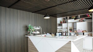 Una cocina moderna con una isla central, armarios blancos y una variedad de utensilios de cocina y elementos decorativos.