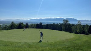A golf course with a clear view of distant mountains and a clear sky. - GENYA Furano (Nakafurano)