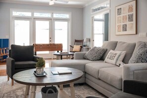 A living room with a sofa, armchairs, a coffee table, and a futsal table.