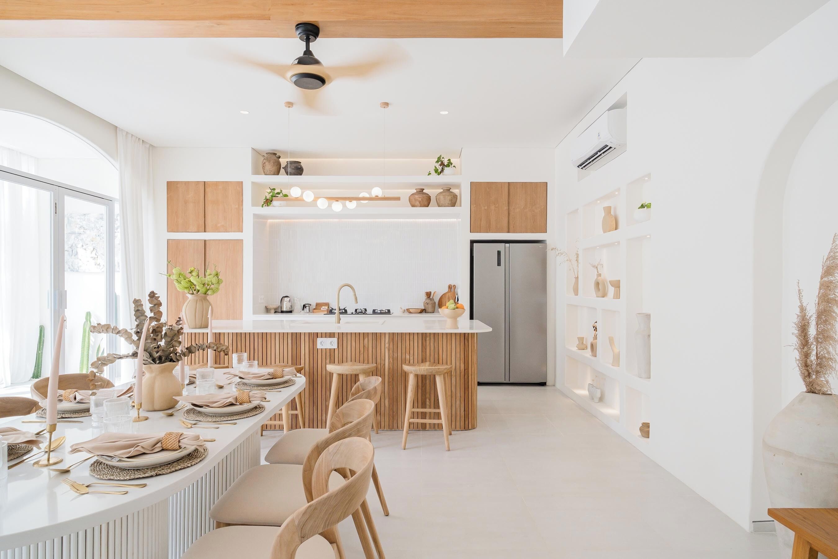 A modern kitchen with a central island, wooden cabinets, and a built-in refrigerator.