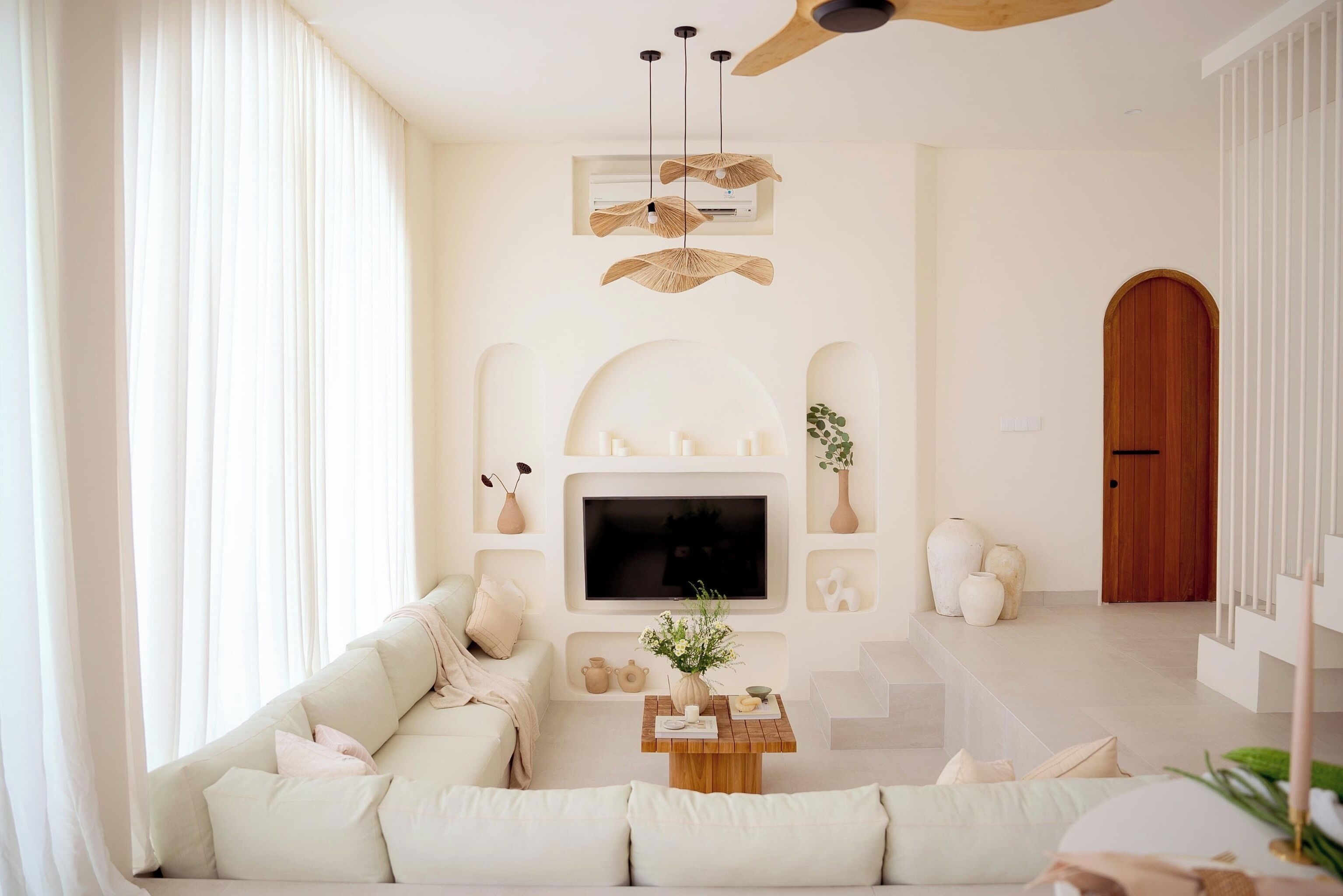 A modern living room with a sofa, TV, and decorative items.