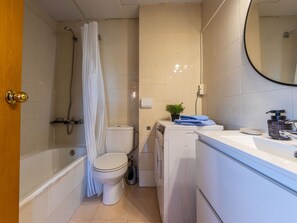 A bathroom with a shower, toilet, washing machine, and sink. - Lovely apartment for 4 people with pool, WIFI, A/C, TV and terrace (Salou)