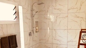 Een badkamer met een douche, een handdoekhouder en een houten ladder.