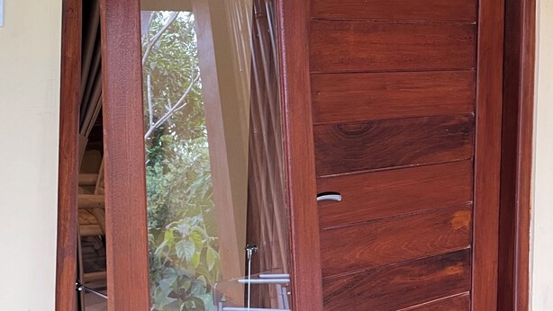 Una puerta de madera con un ventanal corredero.