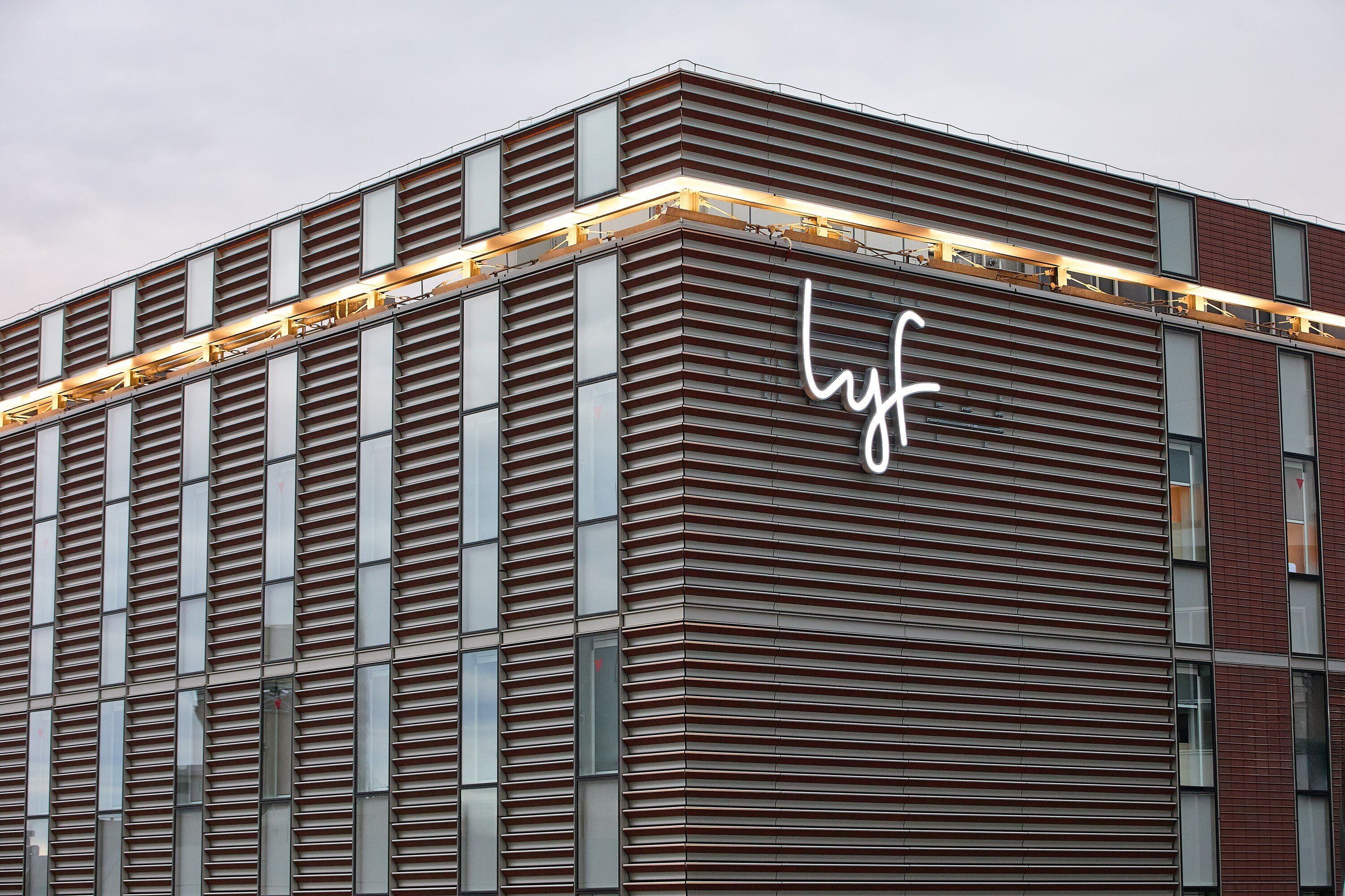 Ein modernes Gebäude mit einem auffälligen 'lyf'-Schild an der Fassade.