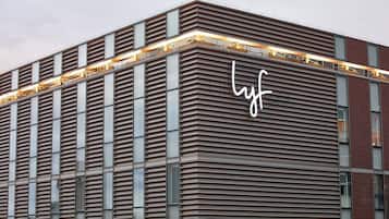 Ein modernes Gebäude mit einem auffälligen 'lyf'-Schild an der Fassade.