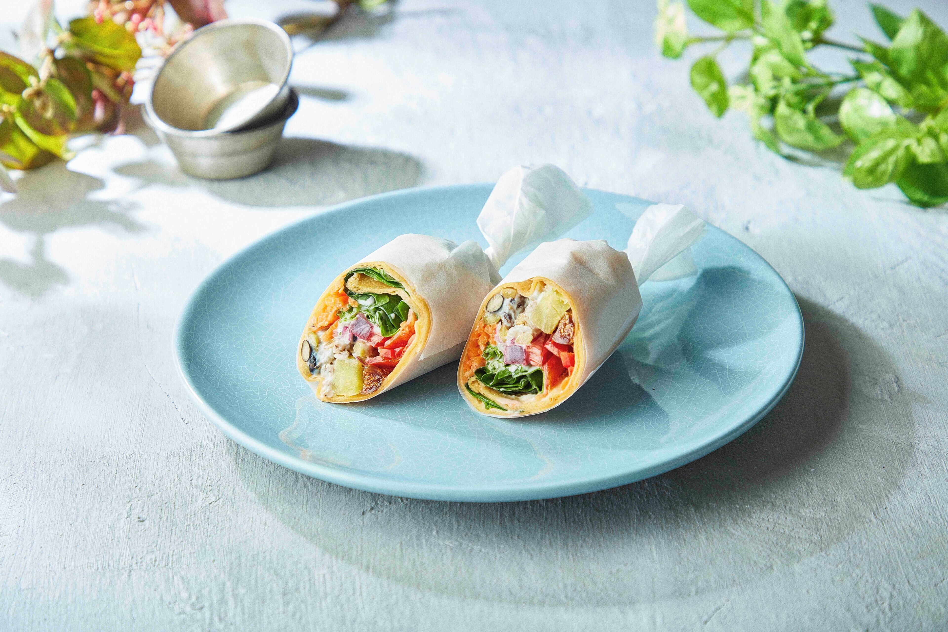 A plate with two wraps on a blue plate.