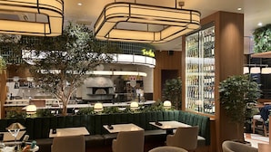 Un restaurant au décor moderne, comprenant un bar, des tables avec des banquettes confortables et un présentoir à vin.