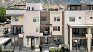 A modern multi-story residential building with a flat roof, large windows, and a balcony. - Superb 4-bedroom townhome in Provo with AC, WiFi (Provo)