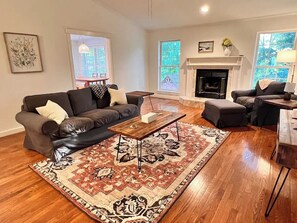 Una sala de estar con chimenea, un sofá, una mesa de centro y una alfombra.