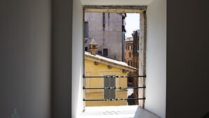 A narrow corridor with a window leading to a street view. - Domus in Lauro (Coronari) (Roma)