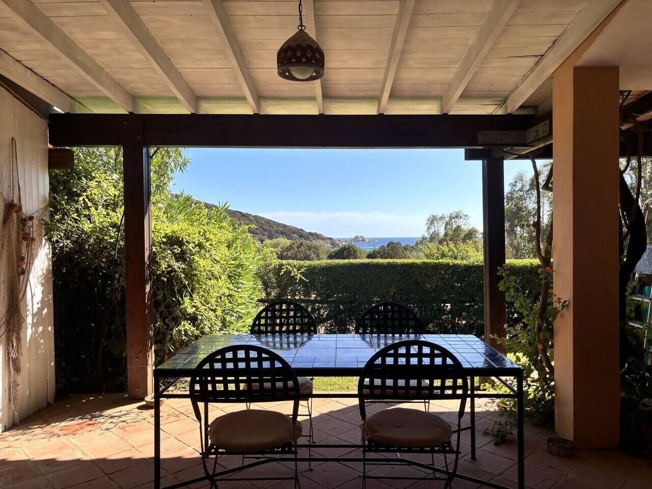 Une terrasse couverte, dotée d’une table et de chaises, qui offre une vue sur un paysage magnifique.