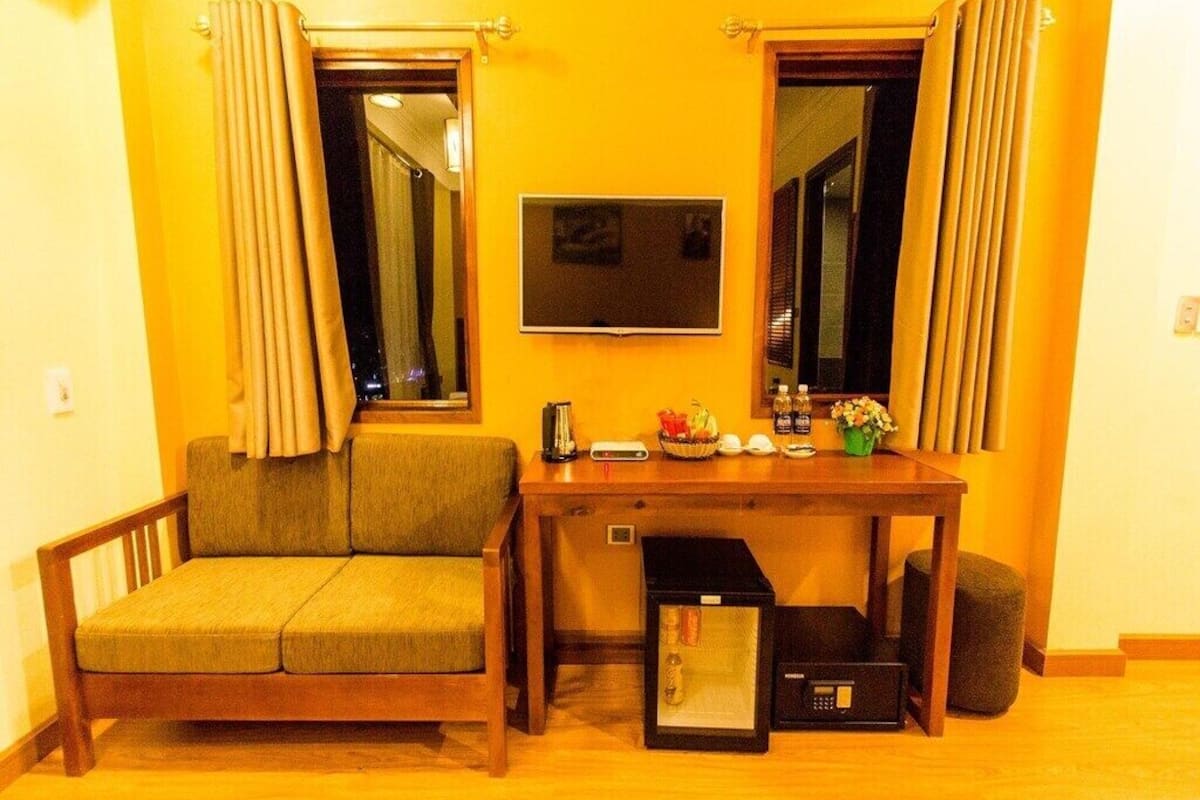 A compact living space with a sofa, a small table, a television, and a microwave.
