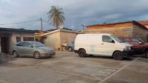 Ein Parkplatz mit einem weißen Lieferwagen und einem silbernen Auto.