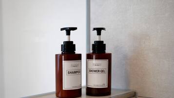 Two bottles of Anhow shampoo and shower gel on a shelf.