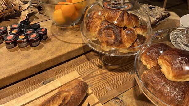 Un bufé de desayuno con pasteles, frutas y salsas.