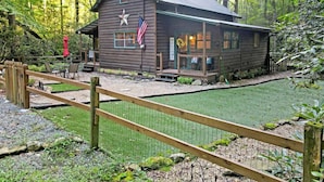 Eine rustikale Holzhütte mit Sterndekoration, einer amerikanischen Flagge und einem Willkommensschild.