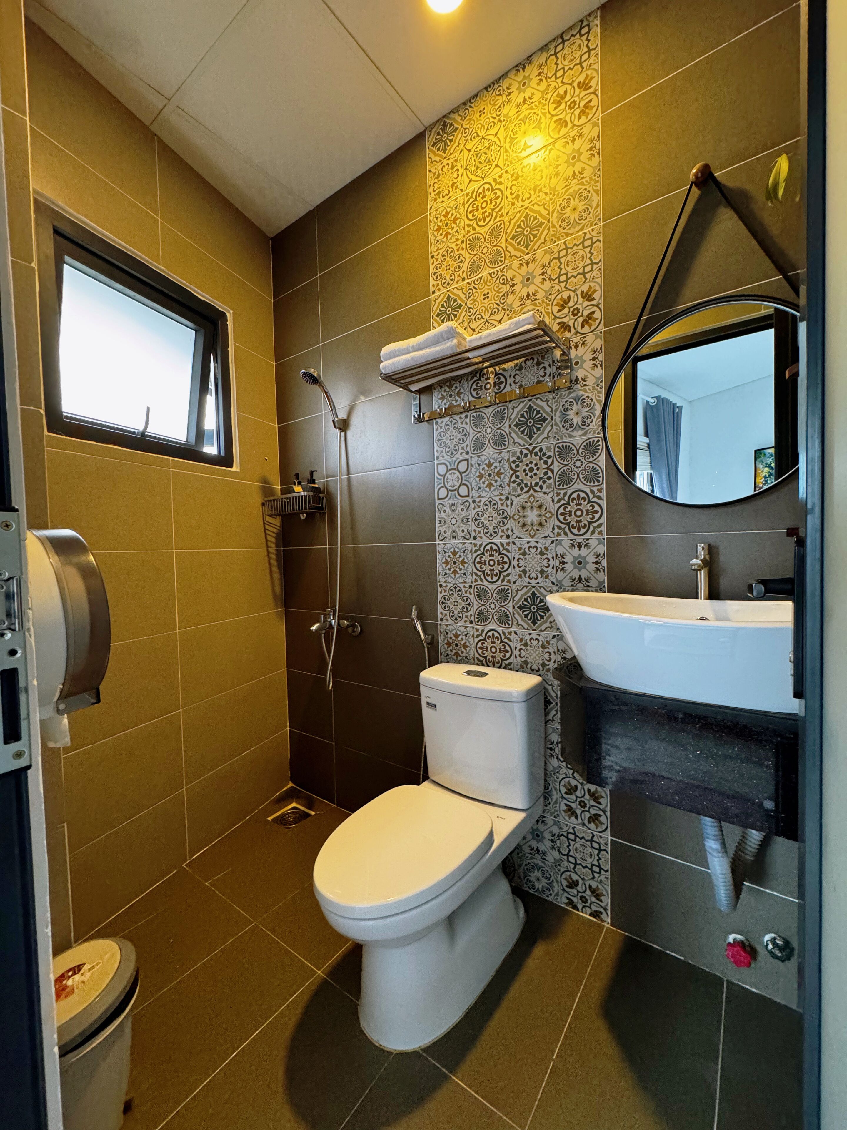 A modern bathroom with a toilet, shower, and sink.