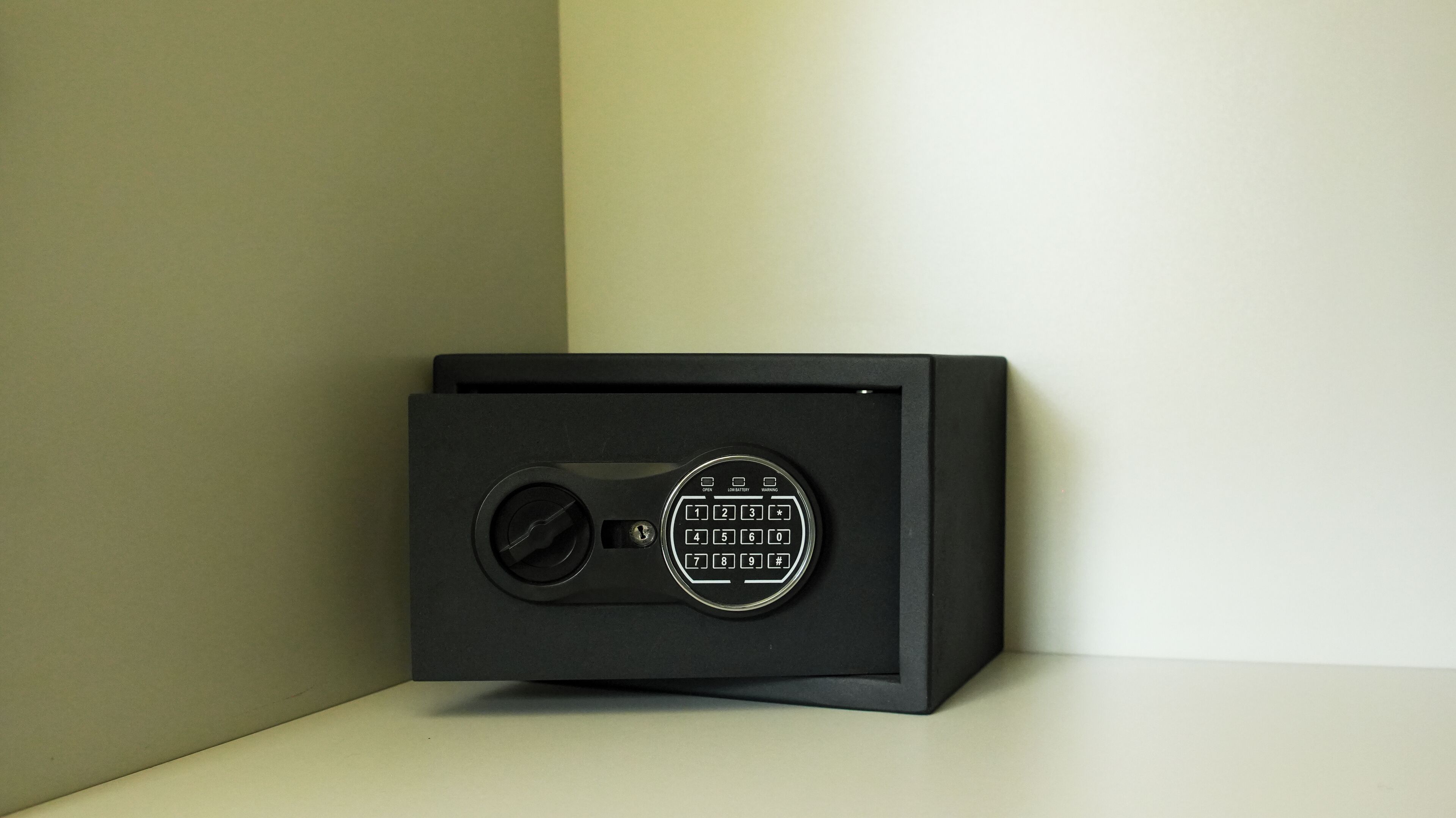 Una caja fuerte negra con un dial de combinación y una etiqueta de advertencia.