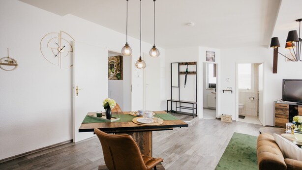 A modern interior with a dining area, a sofa, and a TV. - Apartment 'Ferienwohnung Emma' with Mountain View and Wi-Fi (Güntersberge)