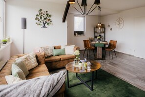 Una sala de estar con sofá, mesa de centro y comedor con sillas y una mesa.