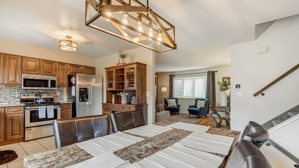 A modern kitchen with wooden cabinets, a built-in microwave, and a stainless steel refrigerator. - Victory Mountain (Colorado Springs)