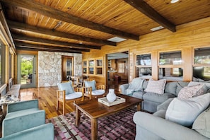 A spacious living area with wooden beams, stone accents, and a large sofa set.