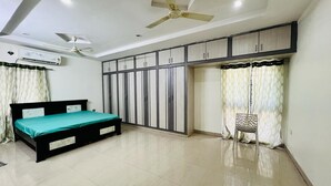 A bedroom with a bed, wardrobe, ceiling fan, and air conditioning unit. - The Excellency Apartments (Hyderabad)