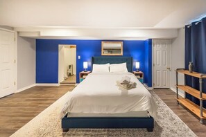 Un dormitorio con cama, mesita de noche, espejo y puerta.