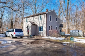 A two-story house with a garage, a driveway, and a snow-covered ground. - Cozy 2BR Loft, Stroll to Downtown A2 (Ann Arbor)